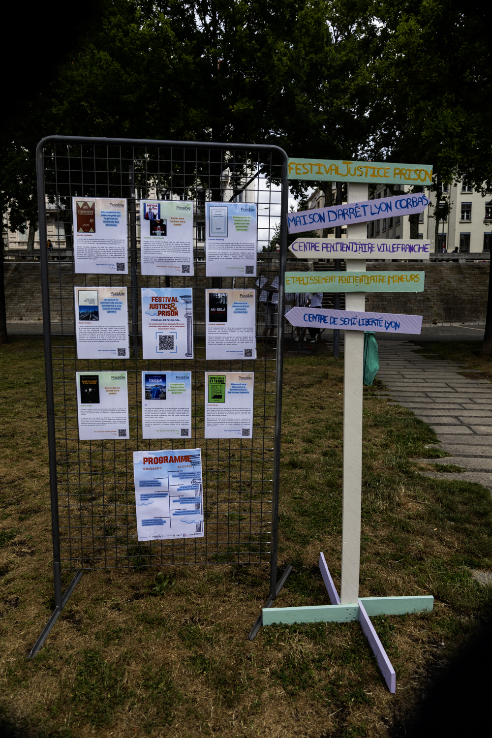 Panneau en grille avec plusieurs fiches accrochées dessus et un panneau avec des flèches indiquant des directions